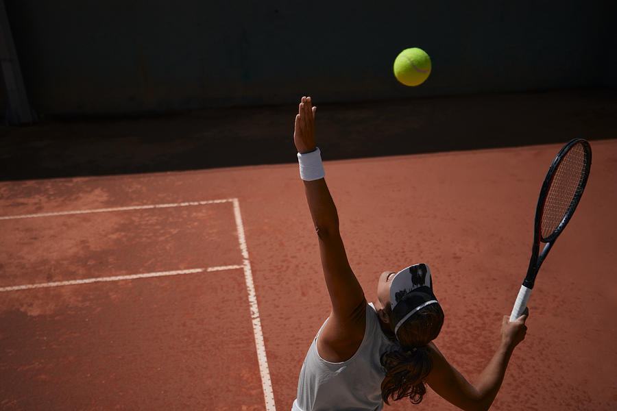 Professional female tennis player serving ball during match Photograph by Wundervisuals