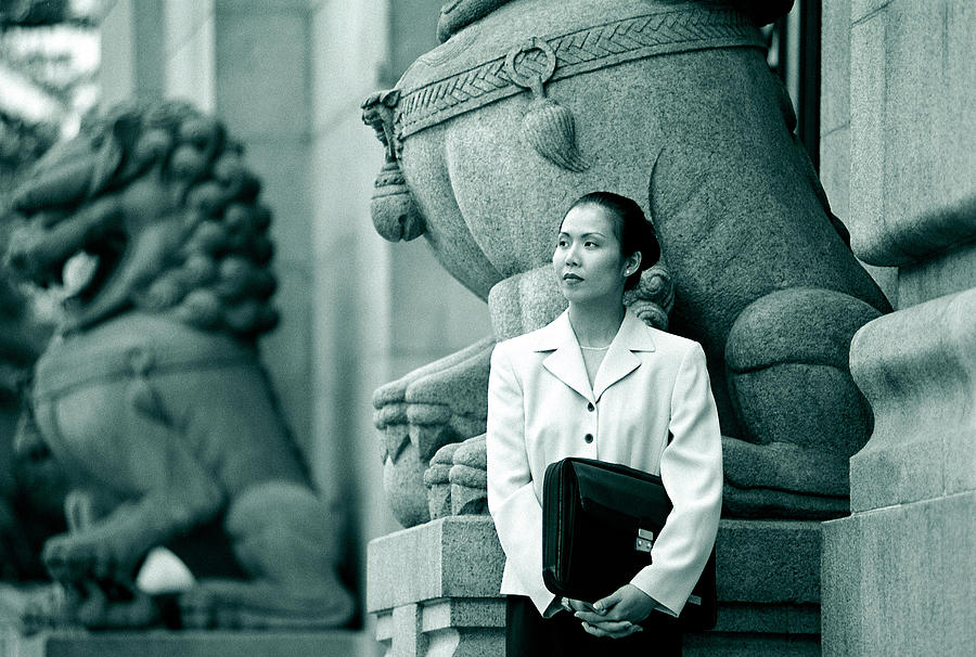 Professional woman waiting by statute Photograph by Photodisc
