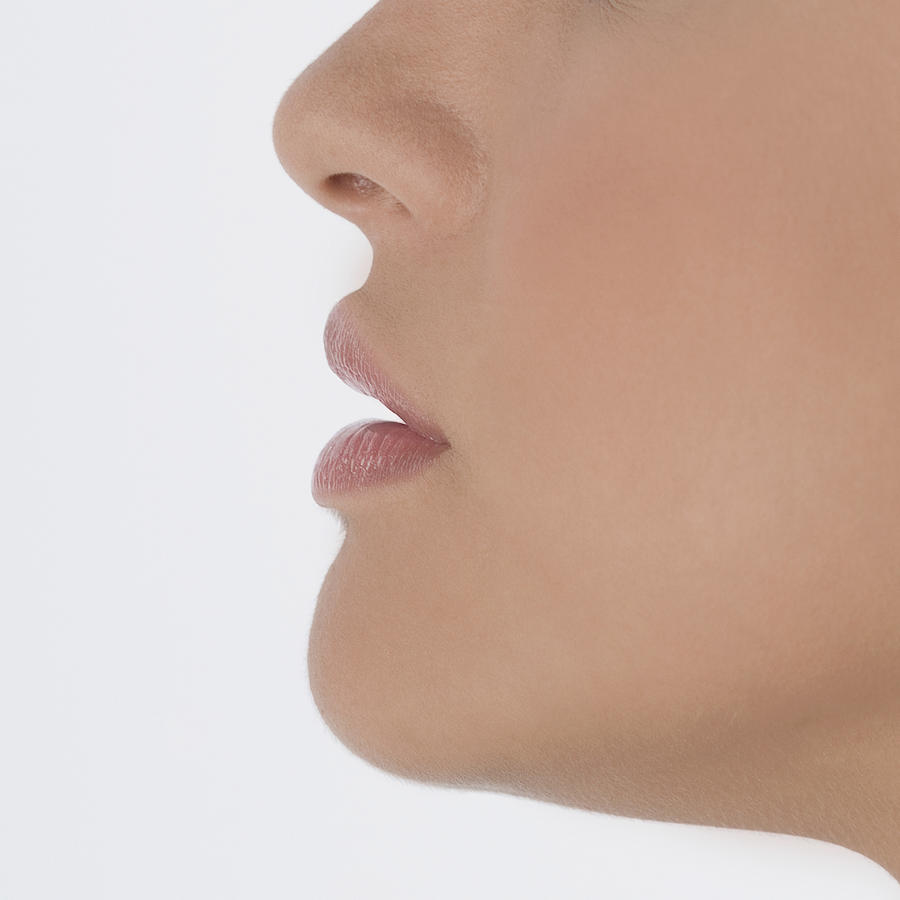 Profile of lower half of young womans face, close-up, part of Photograph by Medioimages/Photodisc