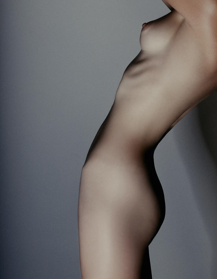 Profile of torso of nude woman stretching Photograph by Jupiterimages