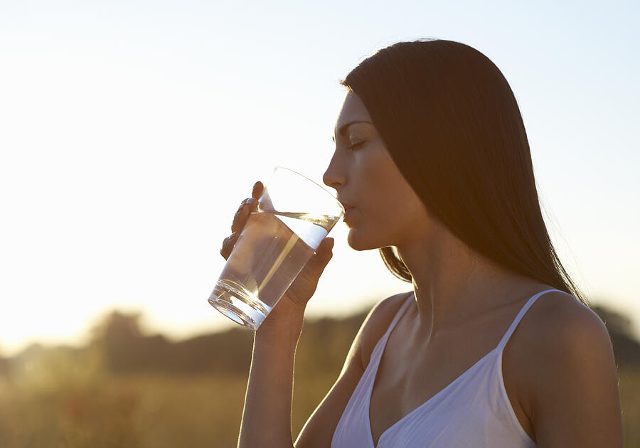 Profile of woman drinking water on hot Summers day Photograph by Dougal Waters