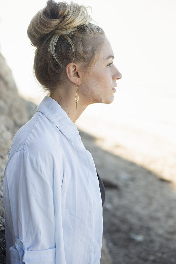 Profile portrait of a blond woman with a hair bun. Photograph by Mint Images