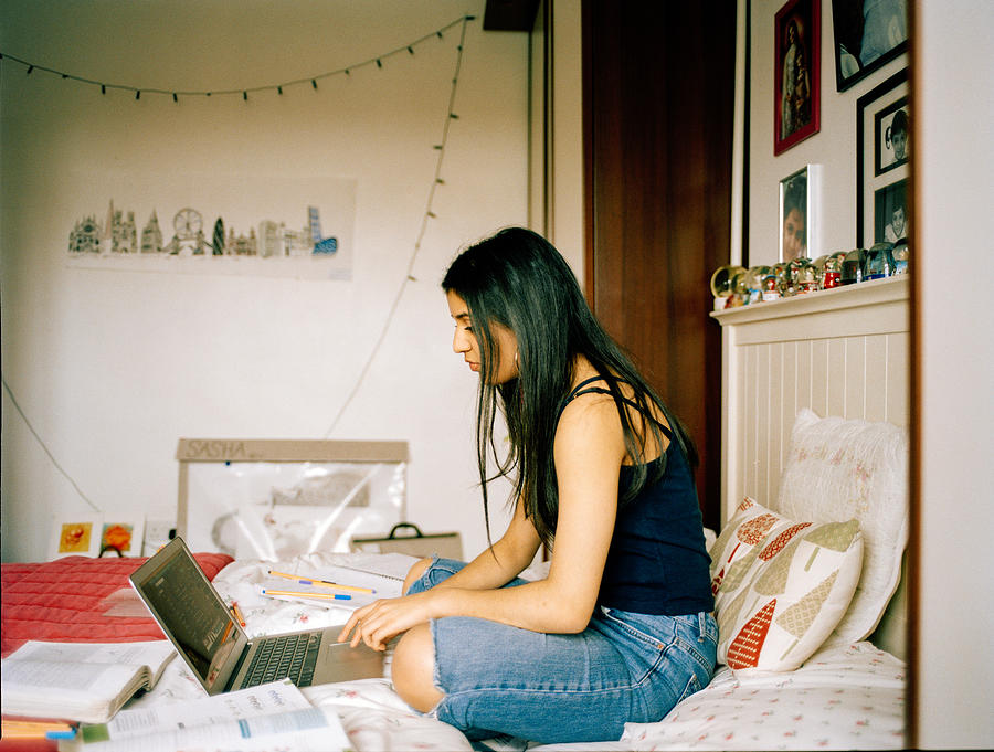 Profile Shot Of Teenage Girl In Her Bedroom, Working On Laptop Photograph by Alys Tomlinson
