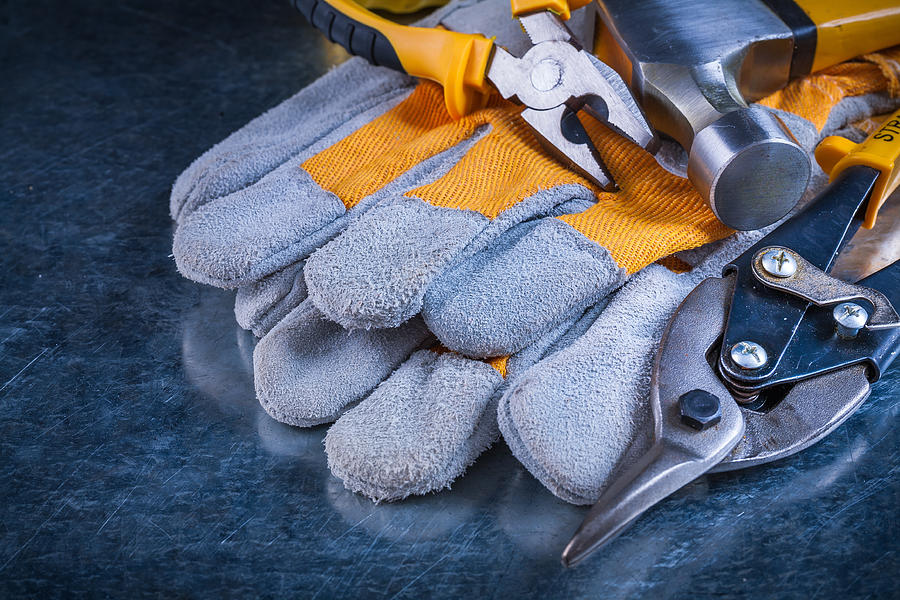 Protective gloves with claw hammer pliers and tin snips on Photograph by Mihalec