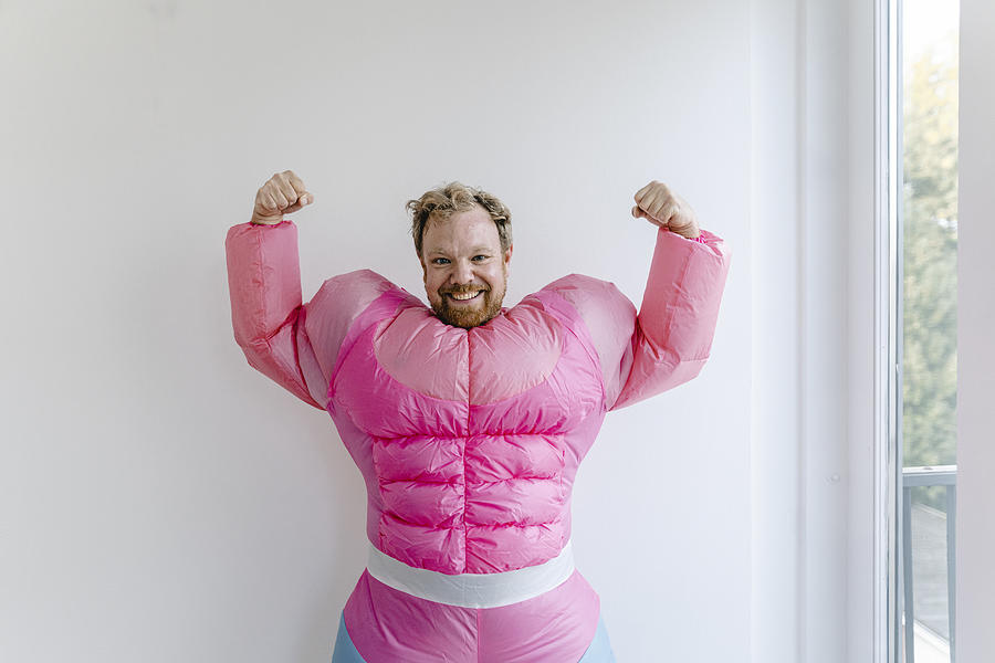 Proud man wearing pink bodybuilder costume flexing his muscles Photograph by Westend61