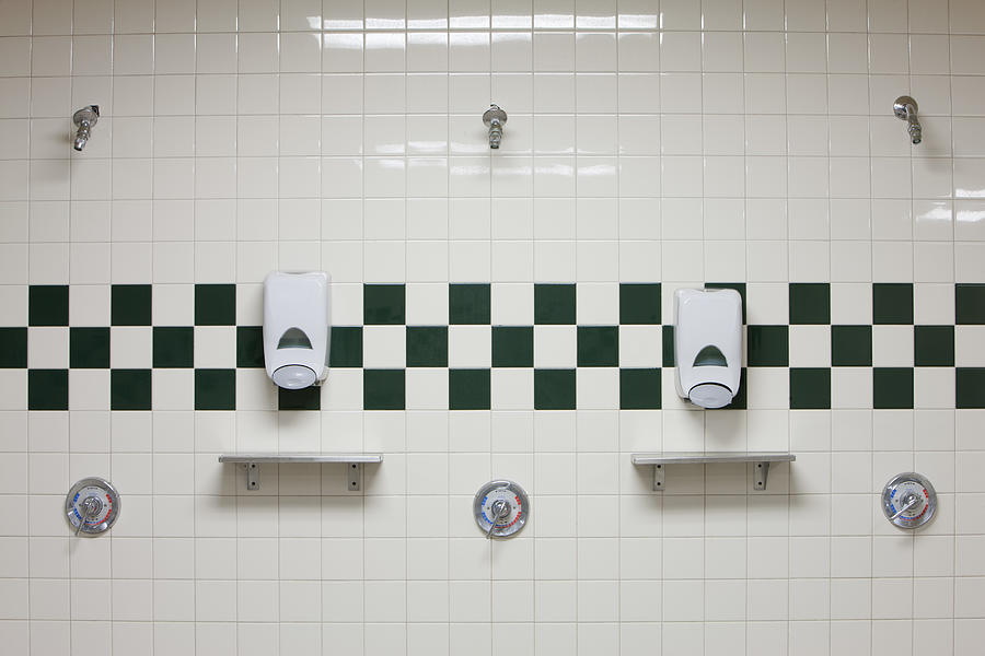 Public shower room with soap dispensers on wall Photograph by PhotoAlto/Sandro Di Carlo Darsa
