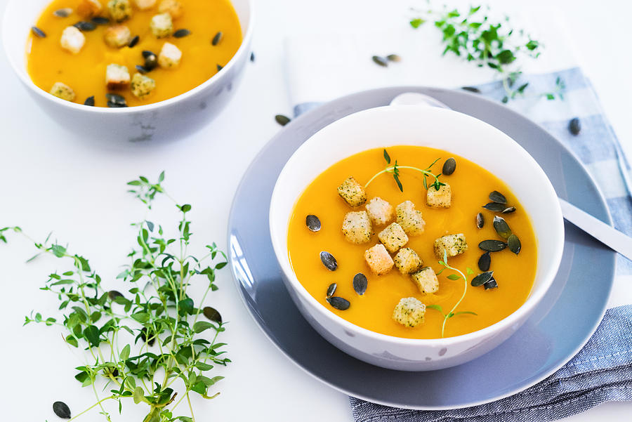 Pumpkin soup served with croutons and pumpkin seeds Photograph by Alexandra Iakovleva