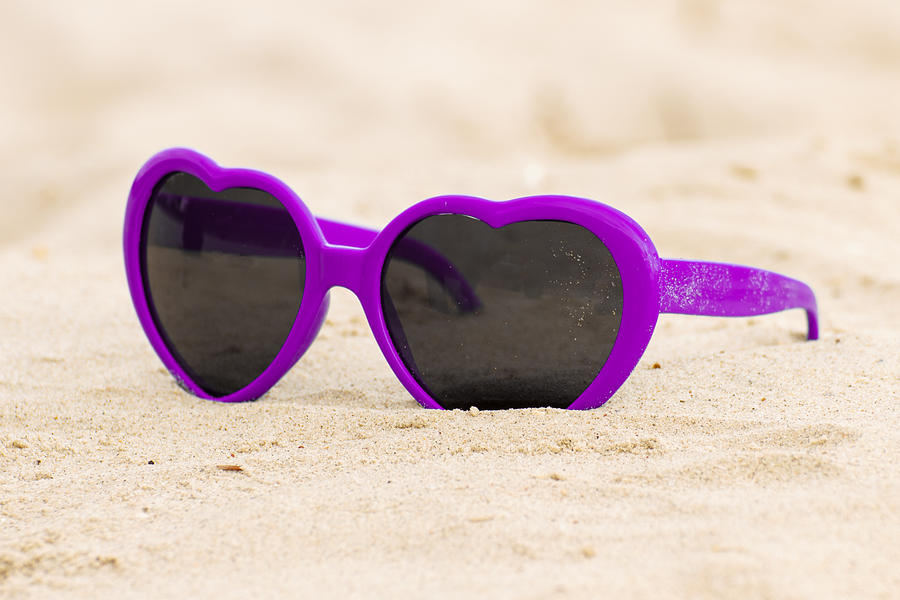 Purple sunglasses shaped heart on the sand Photograph by Ratmaner