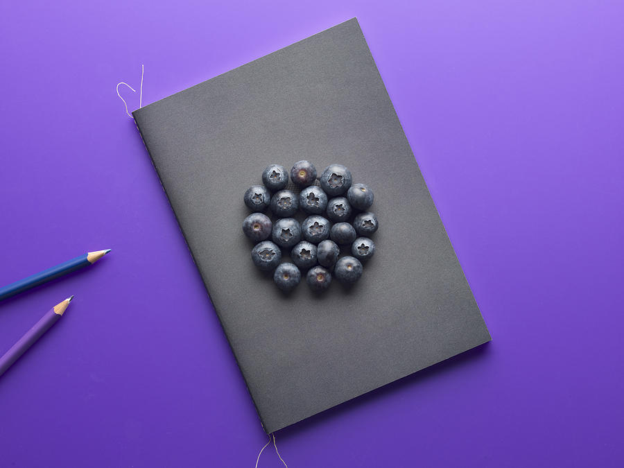 Purple surface shot from above with a notepad and blueberries Photograph by Daniel Day