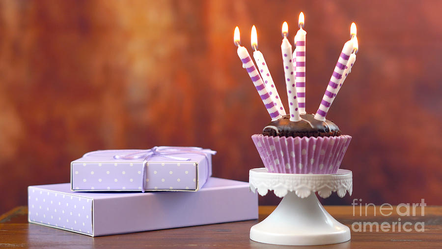 Purple theme birthday cupcake with candles and gift Photograph by Milleflore Images