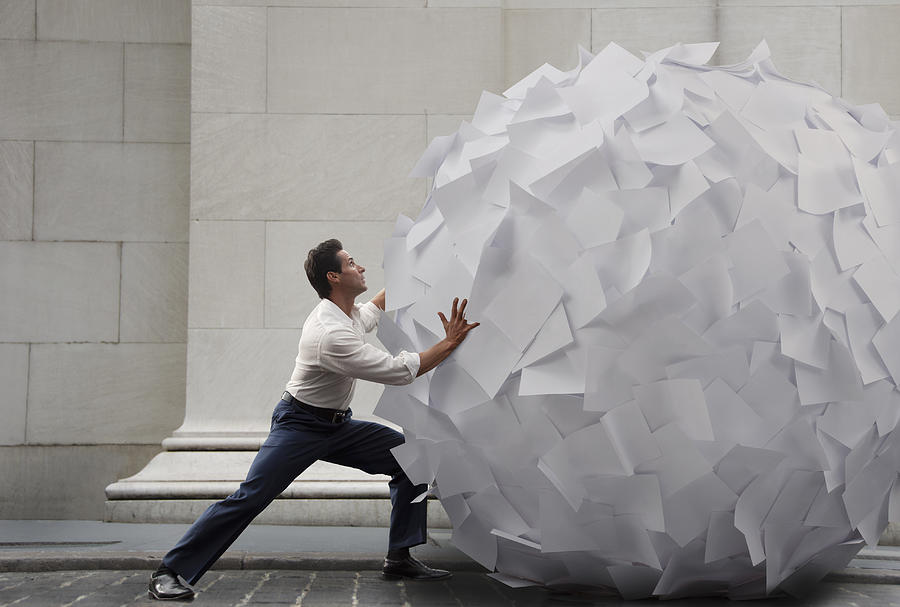 Pushing big ball of paper Photograph by PM Images