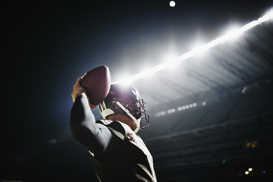 Quarterback preparing to throw pass at night Photograph by Thomas Barwick