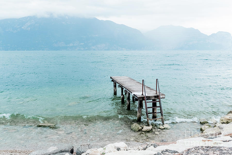 Quiet shore of Lake Garda on a rainy day near the empty jetty. Photograph by Joaquin Corbalan