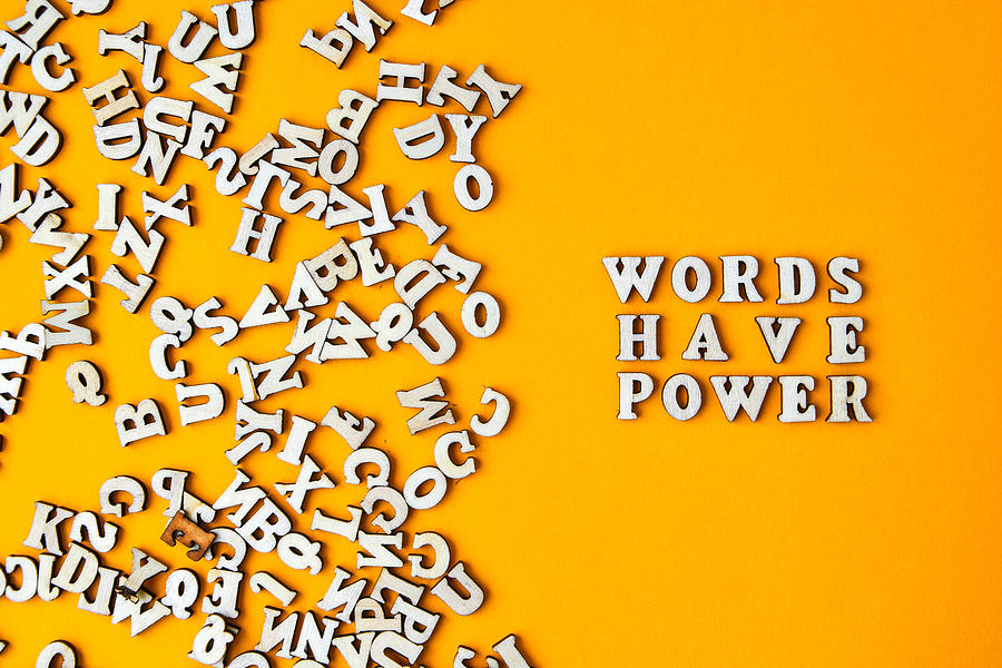 Quote WORDS HAVE POWER made out of wooden letters on bright yellow background. Photograph by Anastasiia Yanishevska