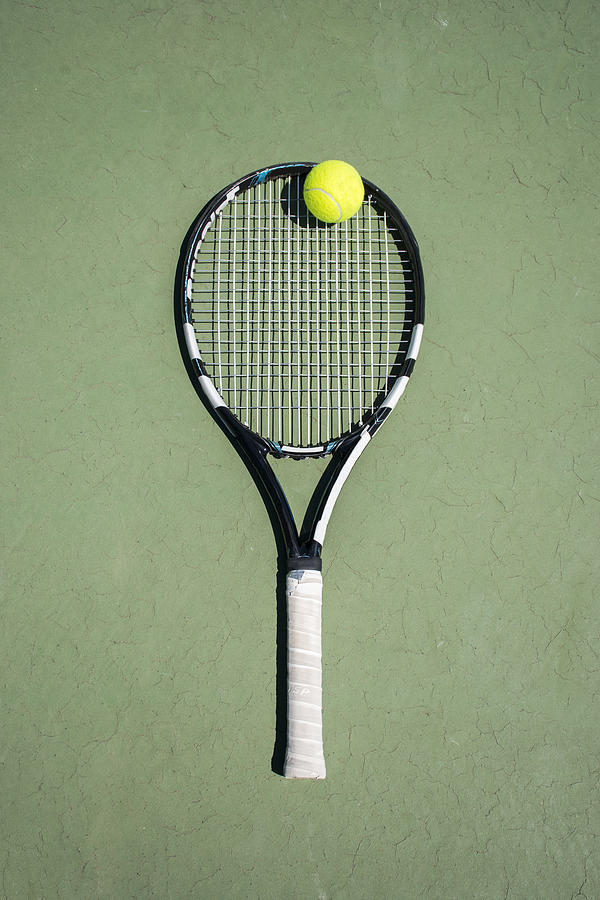 Racket and ball on a tennis court Photograph by Westend61