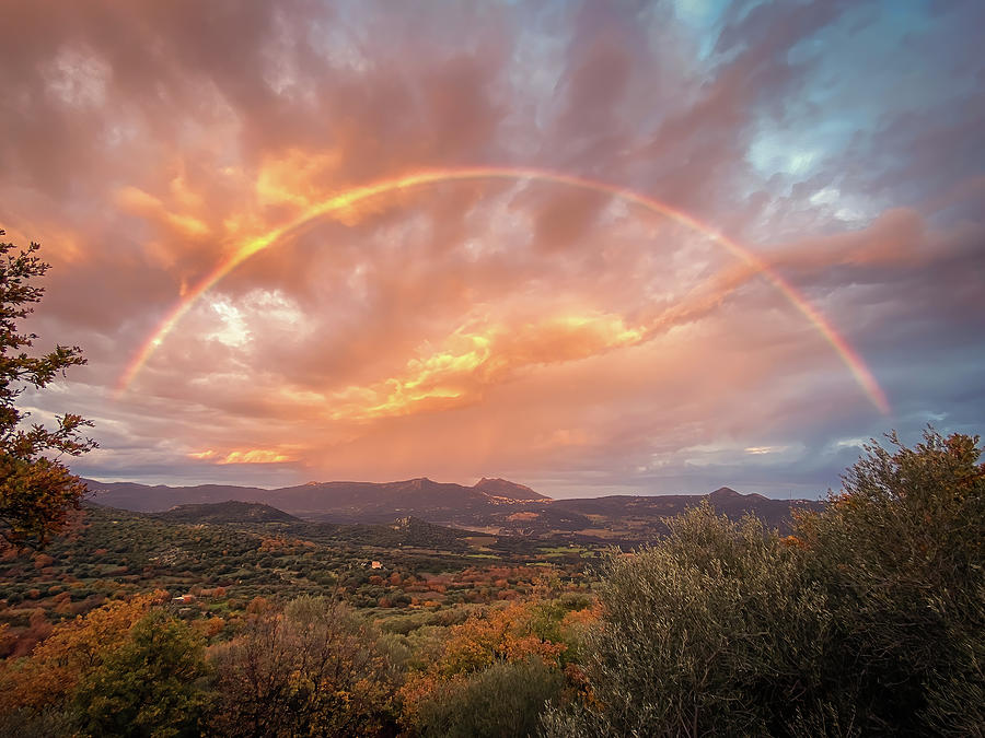 Rainbow over Regino Valley Photograph by Jon Ingall