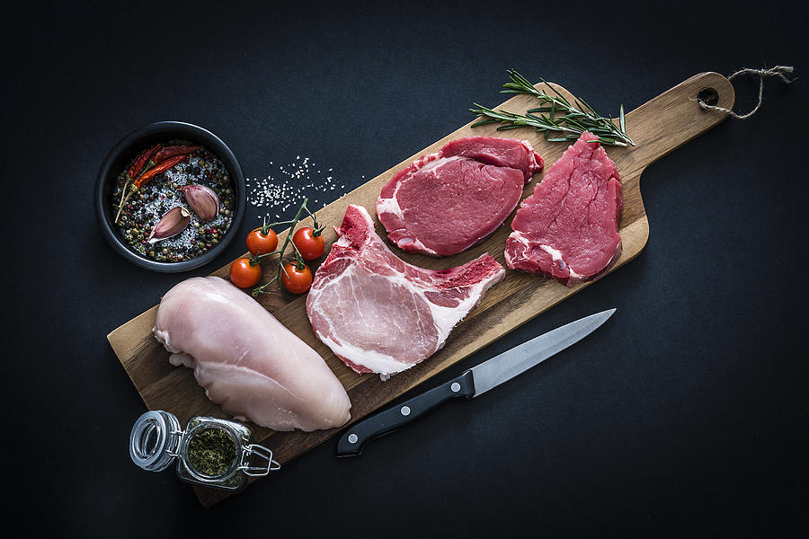Raw meat assortment - Beef, chicken and pork chops shot from above on dark background Photograph by Fcafotodigital