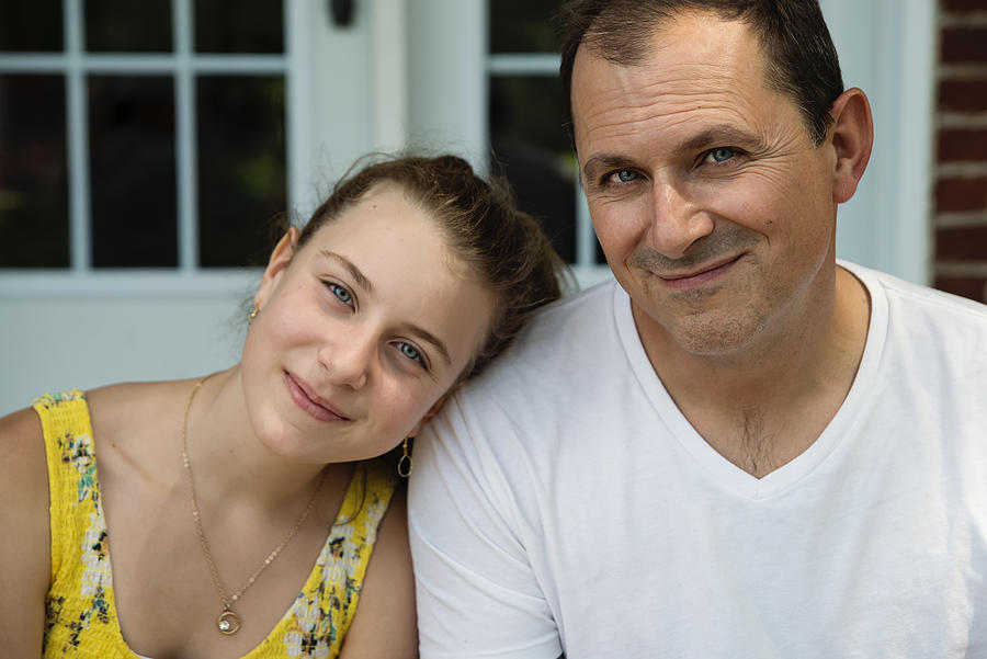 Real family portrait of father and teenage daughter on home porch in summer. Photograph by Martinedoucet