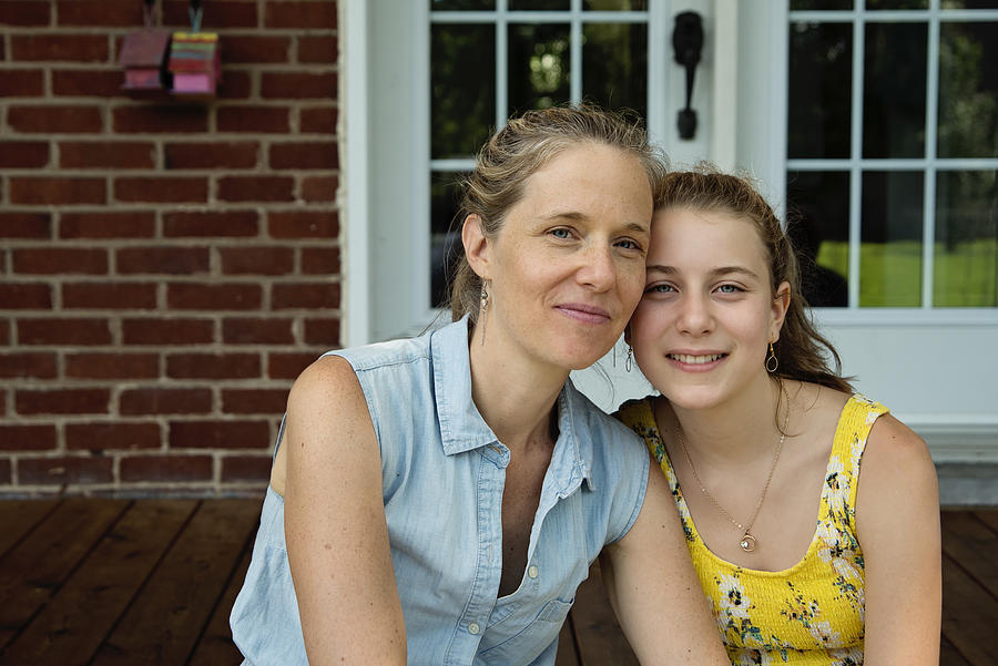 Real family portrait of mother and teenage daughter on home porch in summer. Photograph by Martinedoucet