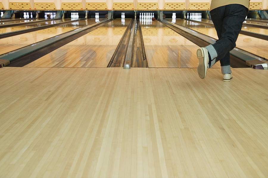 Rear view of a mid adult person bowling Photograph by Colorblind Images LLC
