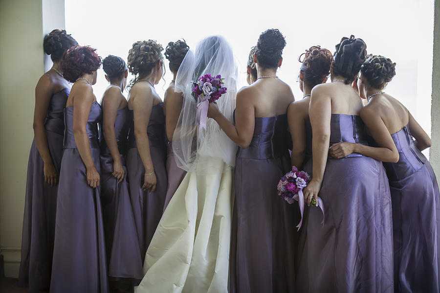 Rear view of bride and bridesmaids looking out window Photograph by Lanny Ziering