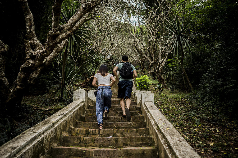 Rear view of couple running up steps to Mount Phousi, Luang Prabang, Laos Photograph by Rosanna U
