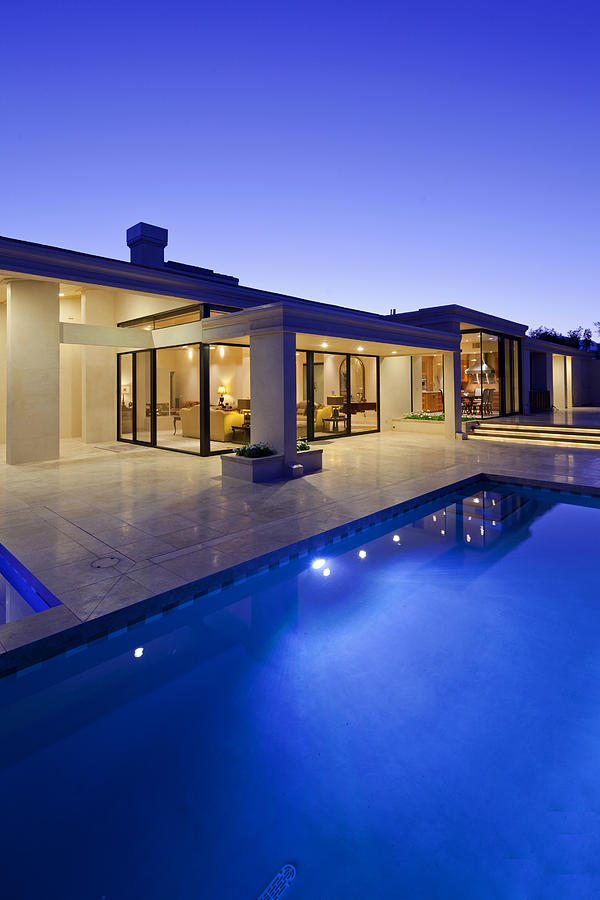 Rear view of luxury villa at night time with swimming pool Photograph by Moodboard
