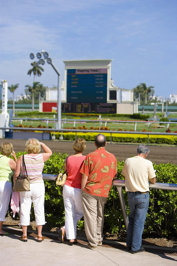 Rear view of spectators standing near the horseracing track Photograph by Glowimages