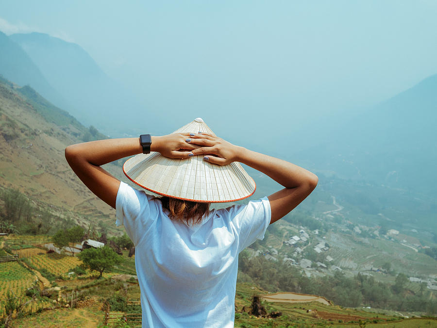 Rear view of Vietnamese style young woman looking at valley Photograph by Photo by Rafa Elias