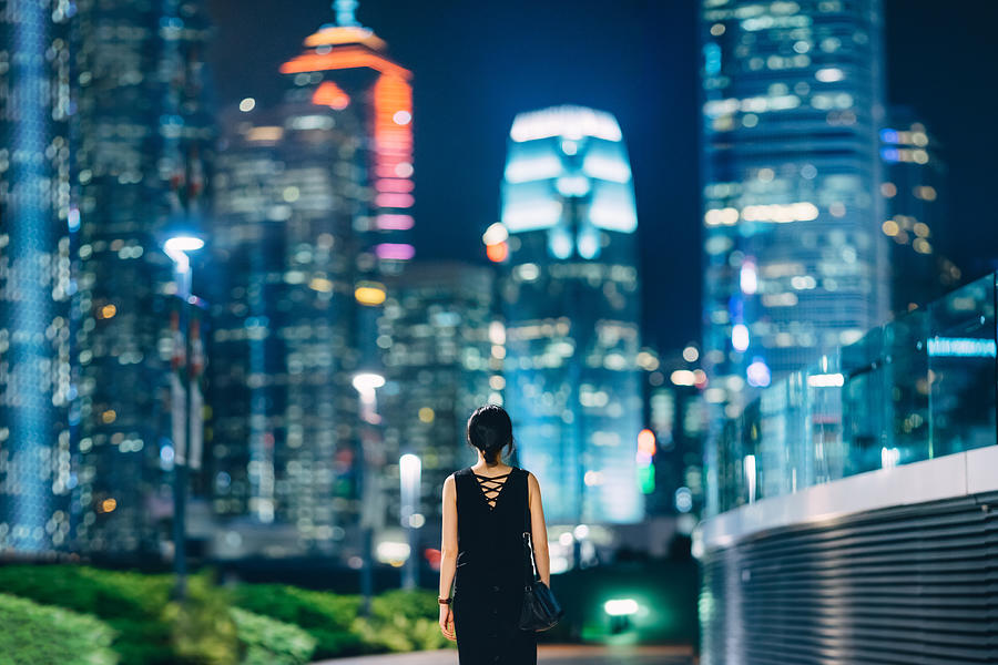 Rear view of woman looking towards contemporary financial skyscrapers in downtown area of Hong Kong Photograph by D3sign