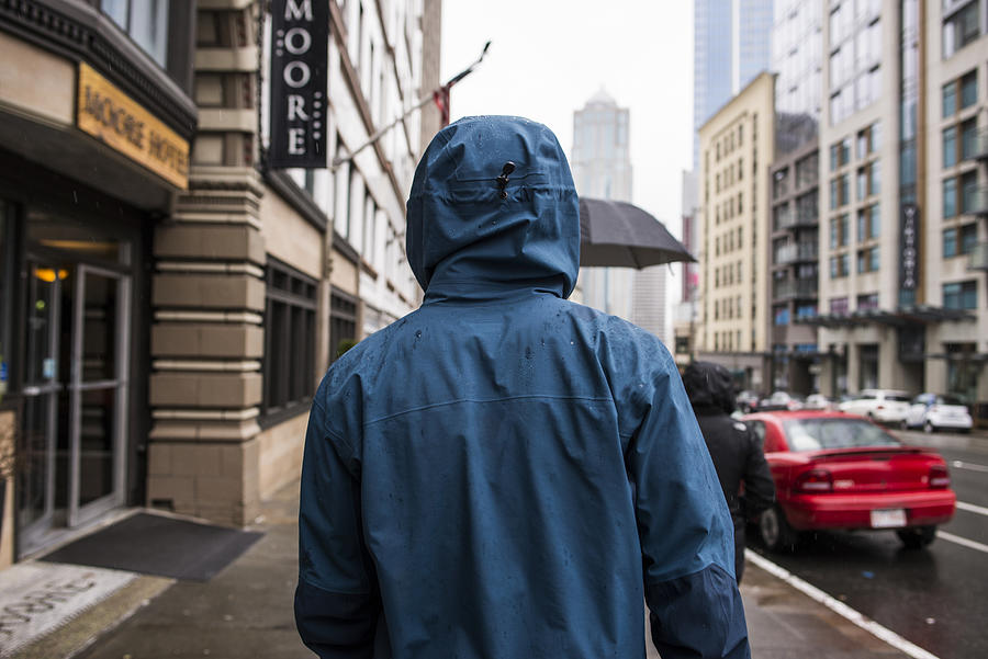 Rear view of young man strolling on rainy street, Seattle, Washington State, USA Photograph by Rosanna U