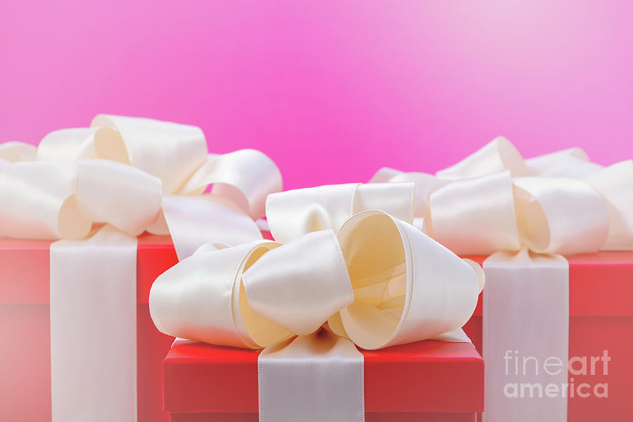Red and white gifts on pink background.  Photograph by Milleflore Images