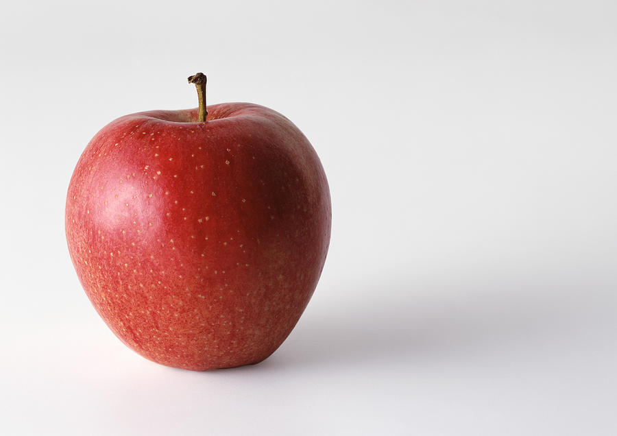 Red apple with stem, in upright position, white background Photograph by Isabelle Rozenbaum
