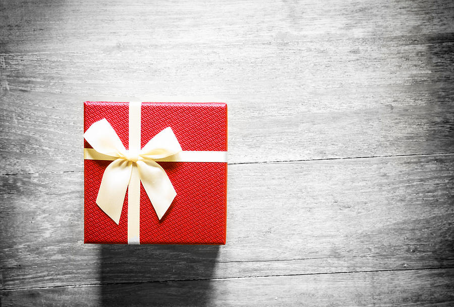 Red christmas gift box on wooden table Photograph by Busakorn Pongparnit