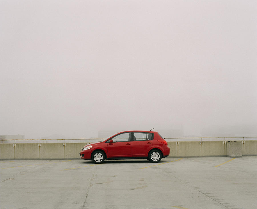 Red compact car on top of parking garage in fog Photograph by Christopher Wurzbach
