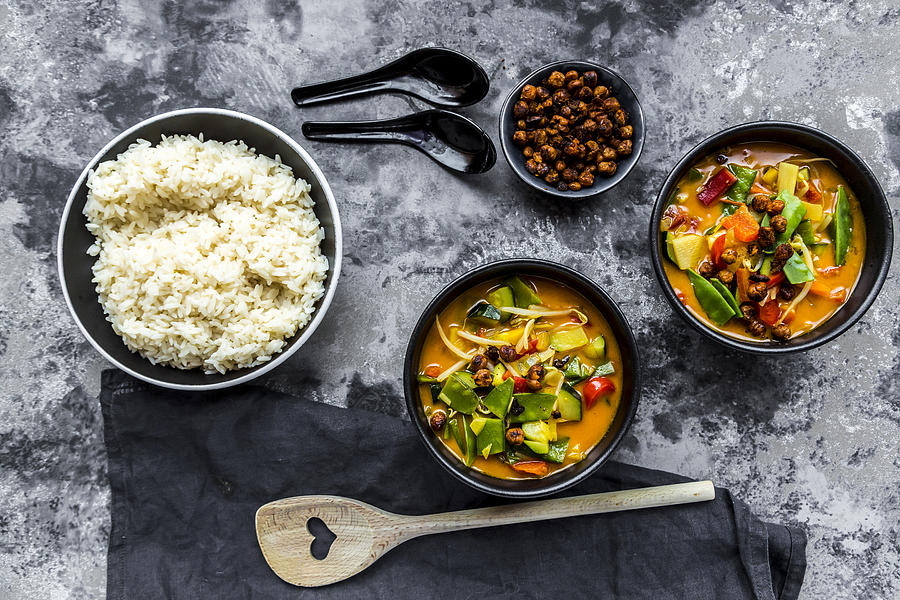 Red curry in bowls, rice and roasted chickpeas Photograph by Westend61