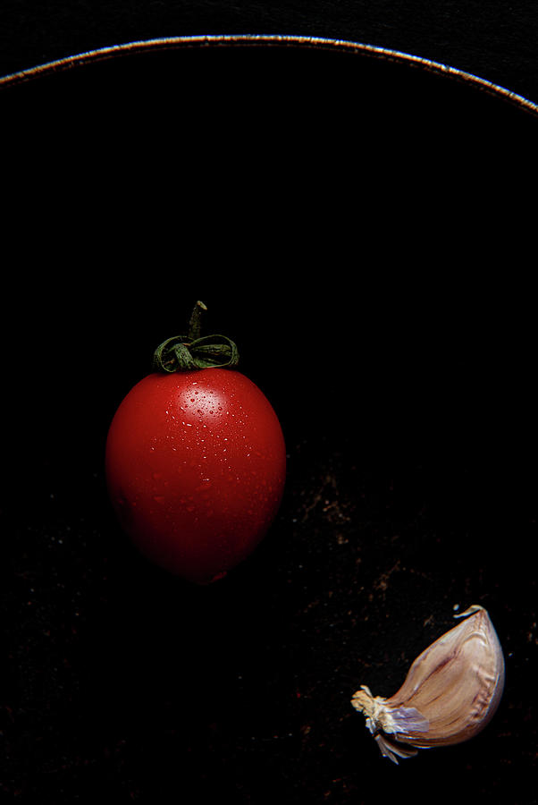 Red fresh healthy tomato and garlic on a black pan Photograph by Michalakis Ppalis