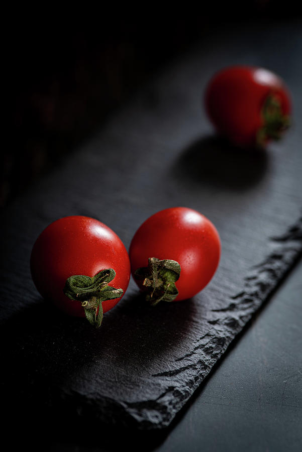 Red Fresh Healthy Tomatoes Isolated On A Black Surface Photograph