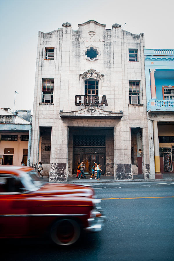 Red oldtimer car passing Cuba sign Photograph by Merten Snijders