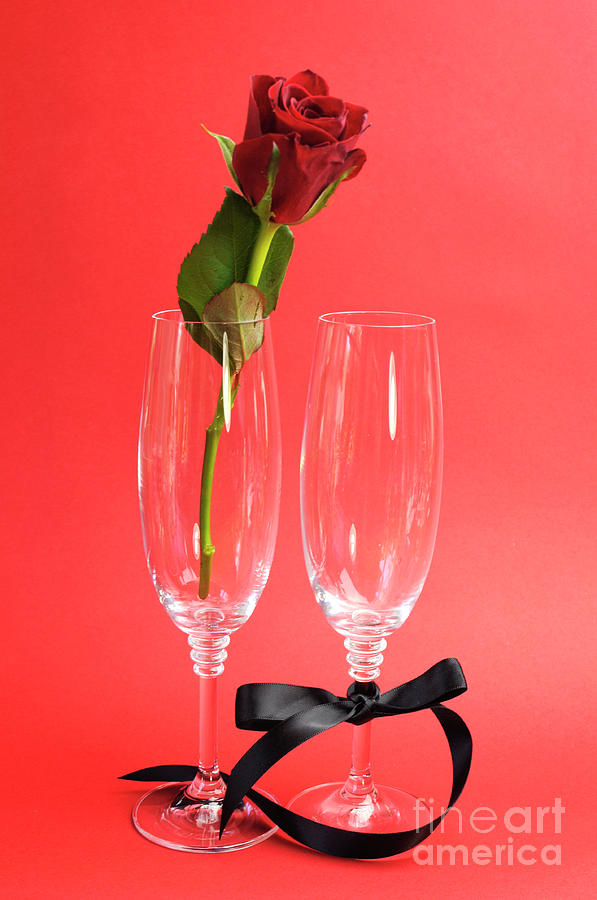 Red rose in champagne glasses Photograph by Milleflore Images