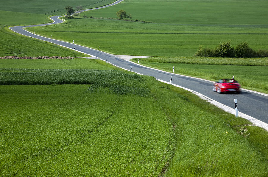 Red Sports Car Speeding on Rural Winding Road in Spring Photograph by Bim