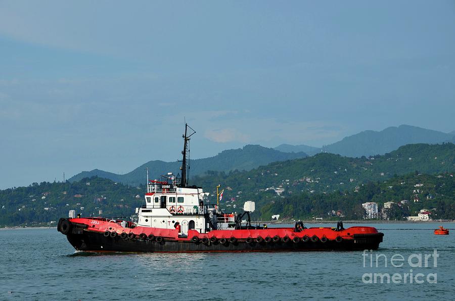 Red tug boat at sea with mountain background traveling in Black Sea Batumi harbor Georgia Photograph by Imran Ahmed