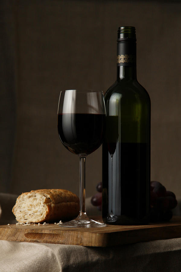 Red wine and peace of bread on table Photograph by DagDurrichPhotography