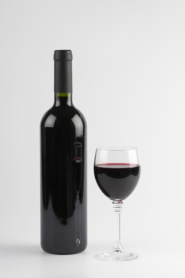 Red wine bottle and glass, isolated on white background Photograph by Mbbirdy