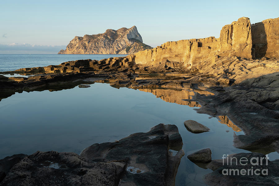 Reflection of rocks in the calm Mediterranean Sea at sunrise 1 Photograph by Adriana Mueller