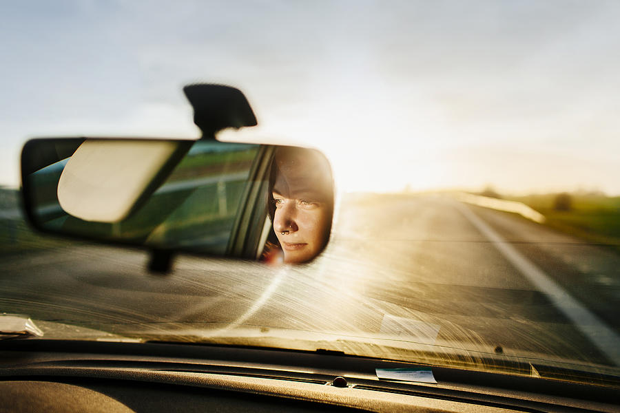 Reflection of woman in rear-view mirror Photograph by Astrakan Images
