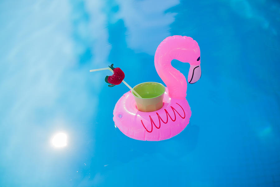 Refreshing beverage in a pink flamingo floating cup holder in the pool Photograph by Carol Yepes