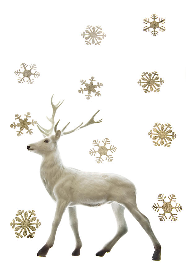 Reindeer figurine and snowflakes Photograph by Image Source
