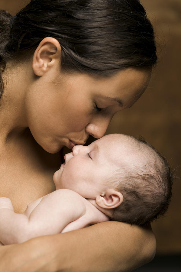 Relationship Portrait Of A Young Adult Mother As She Holds And Kisses Her Newborn Baby Photograph by Digital Vision