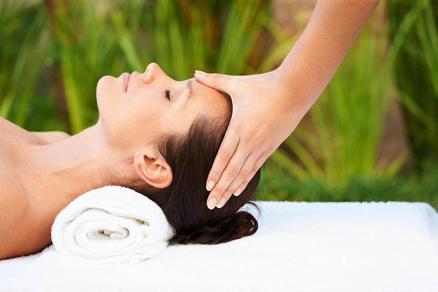 Relaxed mid adult woman receiving head massage Photograph by GlobalStock
